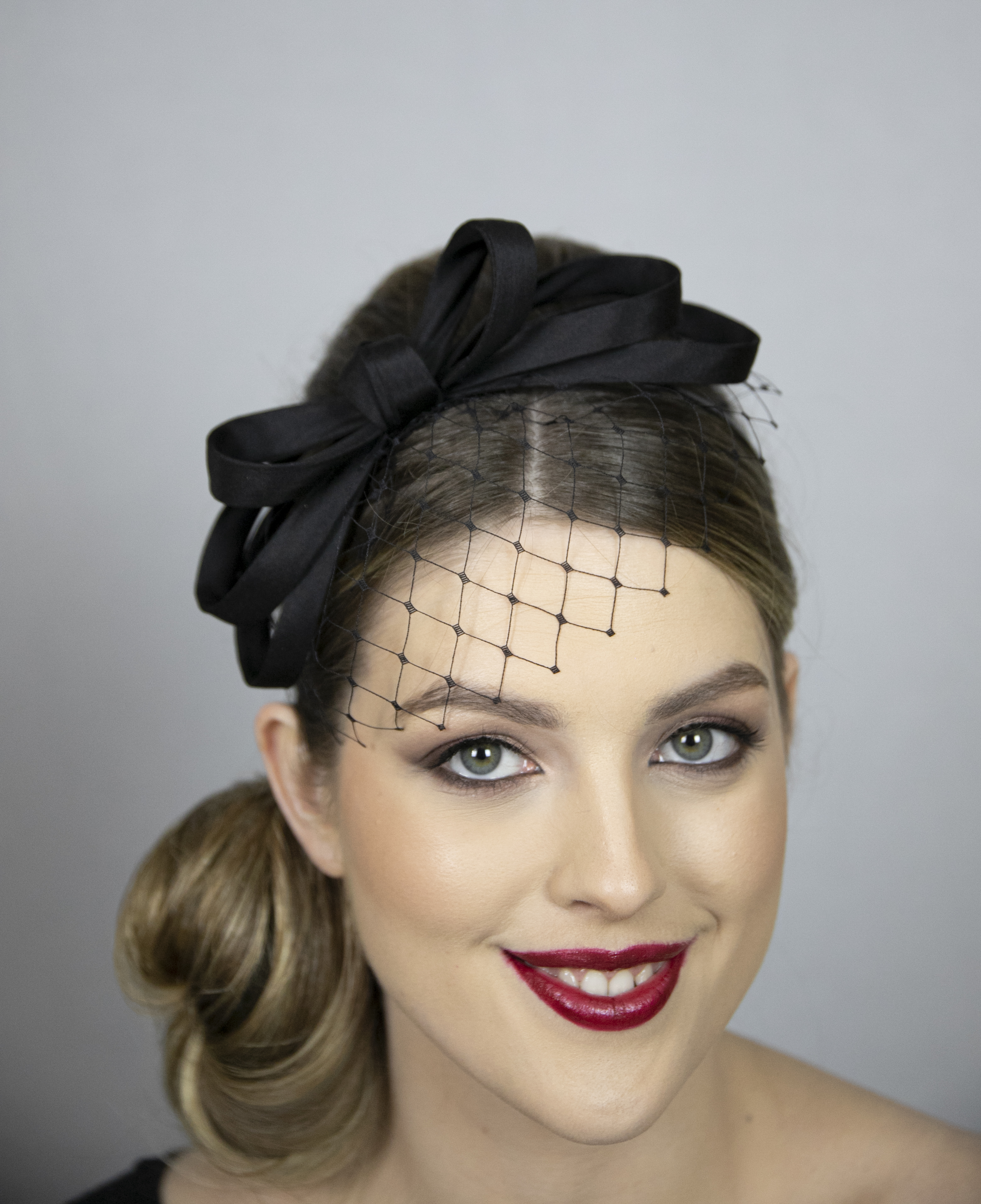 Black fascinator with short net. Very popular design!