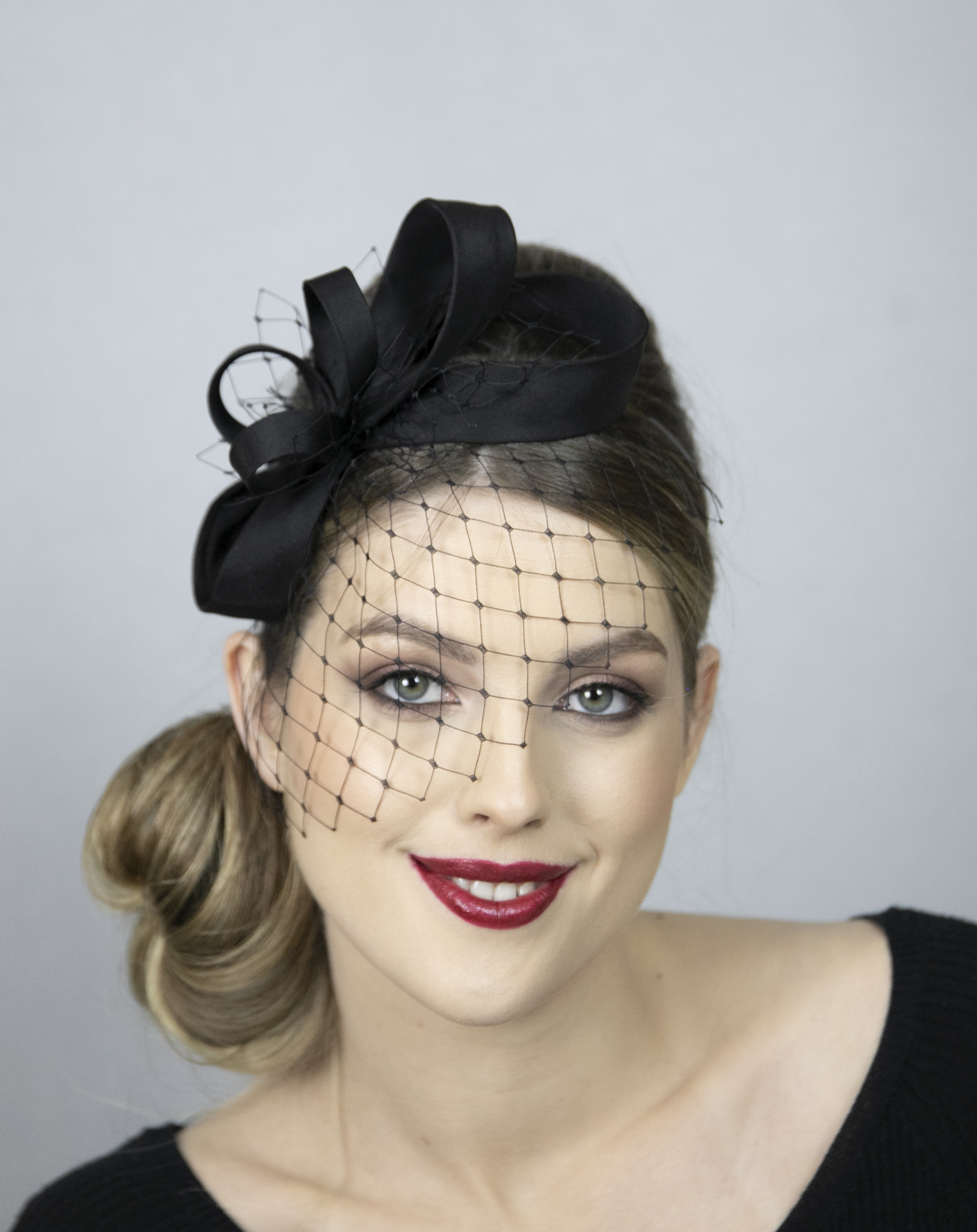Black classical fascinator with face veil.
