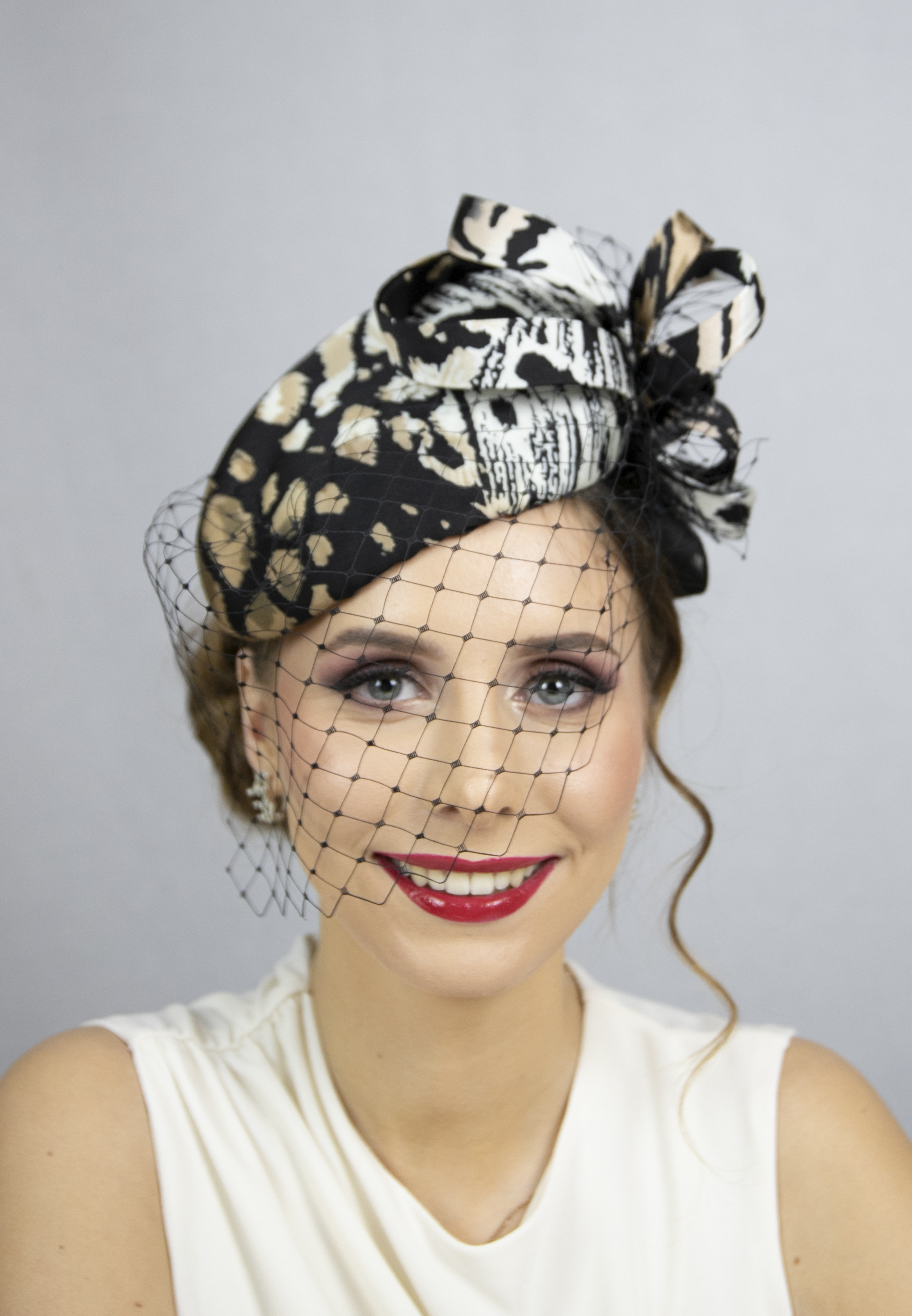 Animal print silk percher hat with face veil.