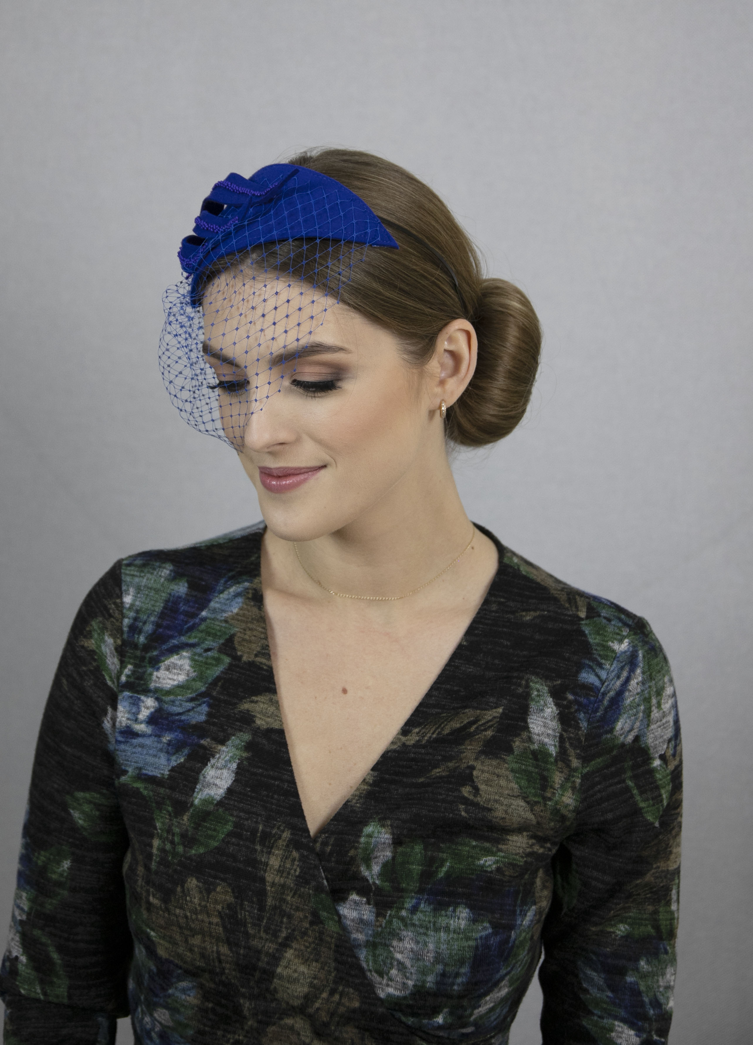 Royal blue fascinator hat with net.